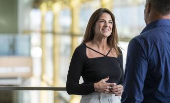 Woman with long hair smiling at man in blue shirt