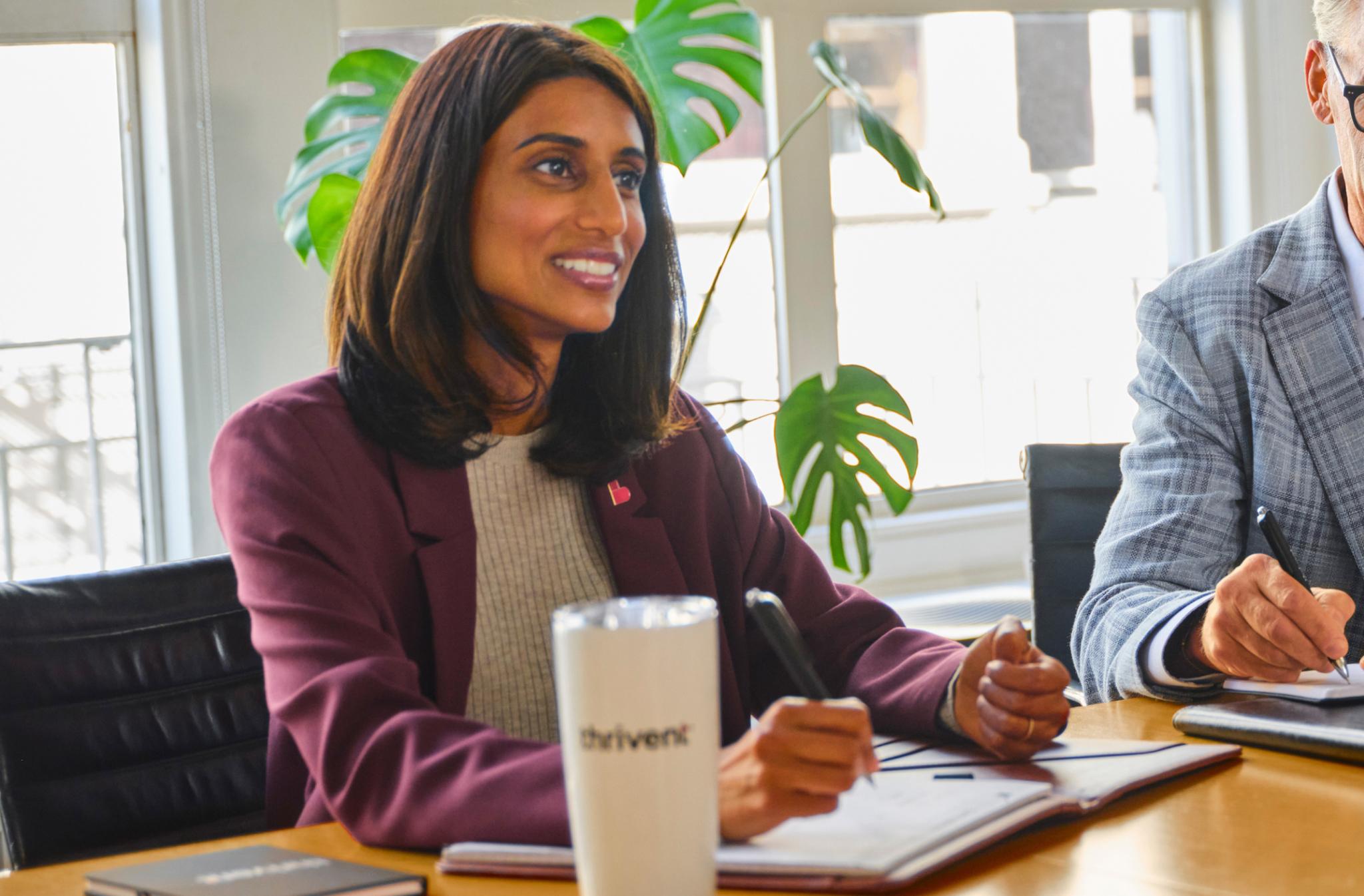 Financial advisor at a table holding a pen
