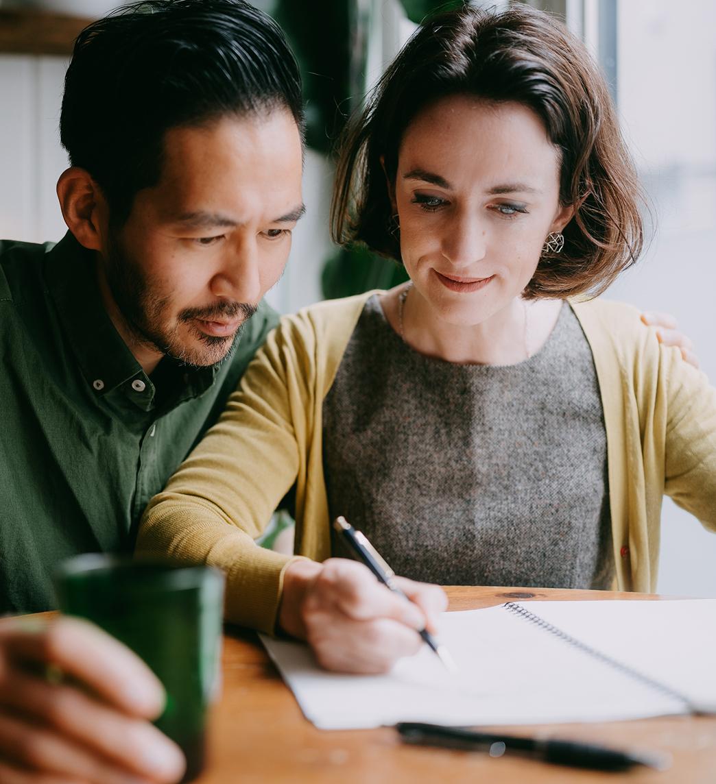 Man and woman writing in a notebook